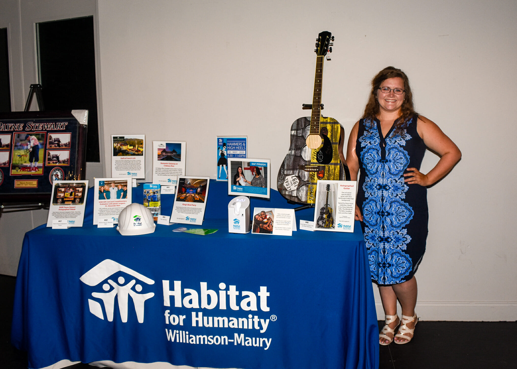 woman posing in front of habitat for humanity table