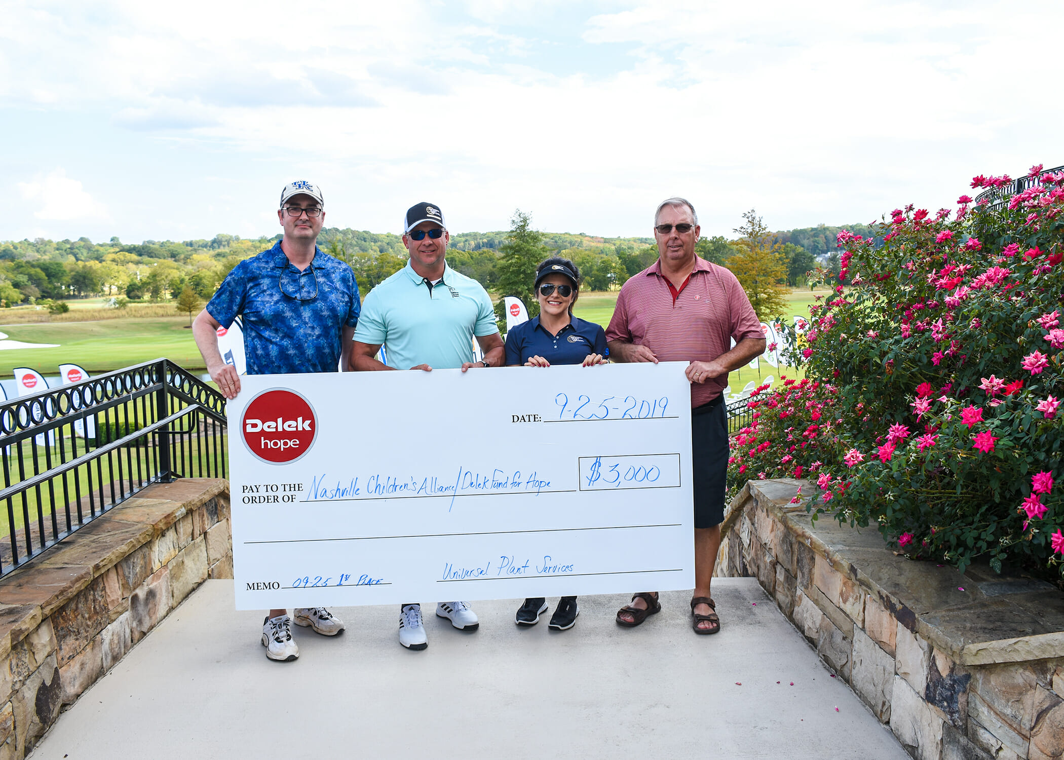 four golfers holding an oversized check